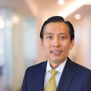 Dave Firdaus in a navy suit and yellow patterned tie