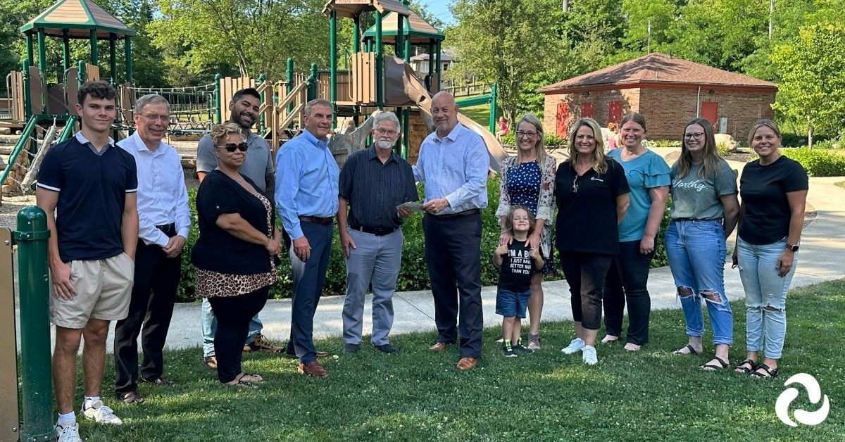 Dave Hershberger and community representatives at a presentation beside playground equipment in Wooster