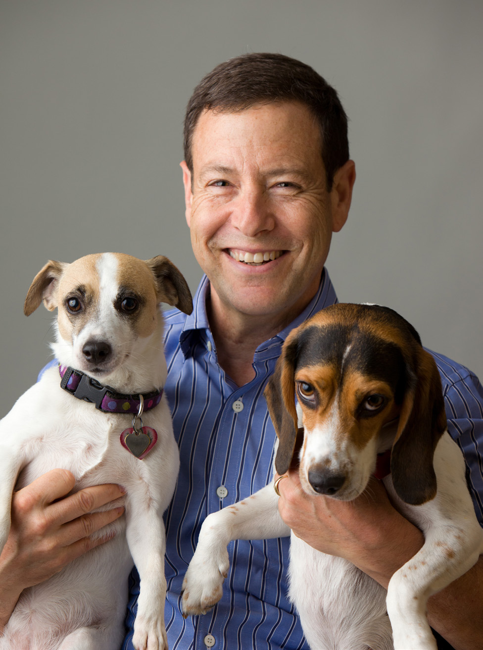 Dave Imre smiling while holding two dogs