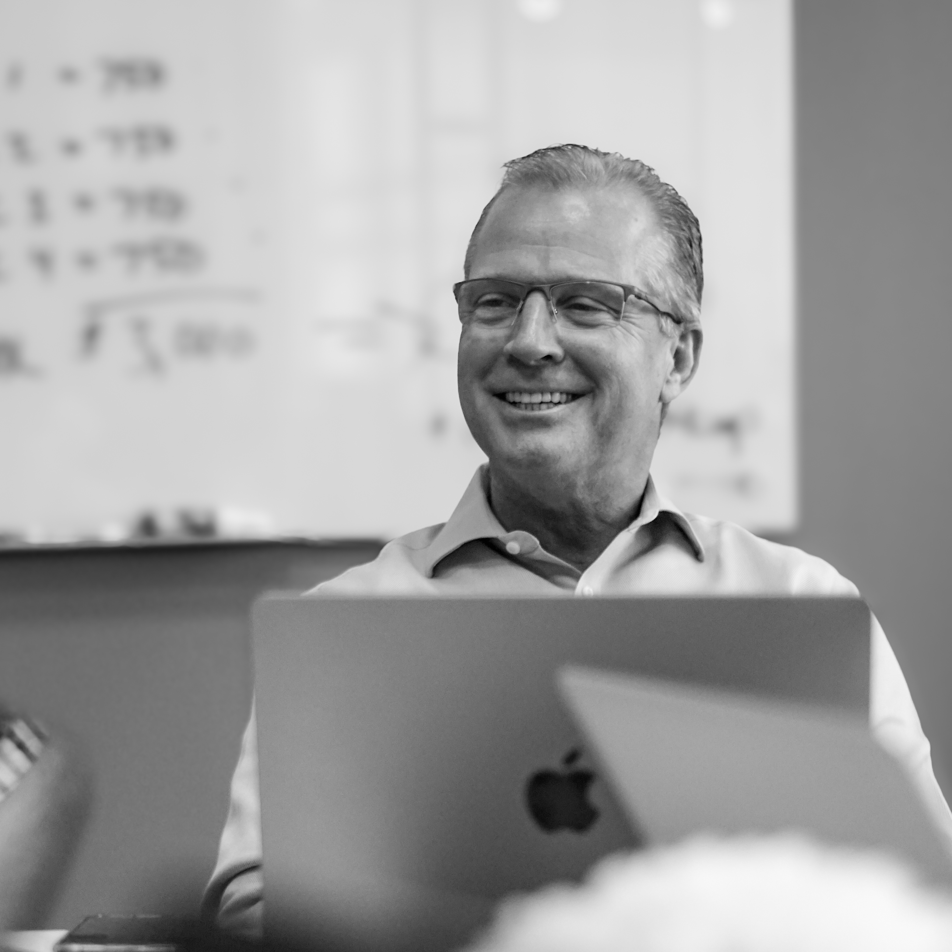 David Anderson smiling behind a laptop at Off Madison Ave