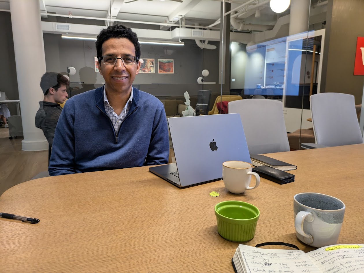 David Barboza at a WireScreen office table with a laptop, notebook and coffee cups