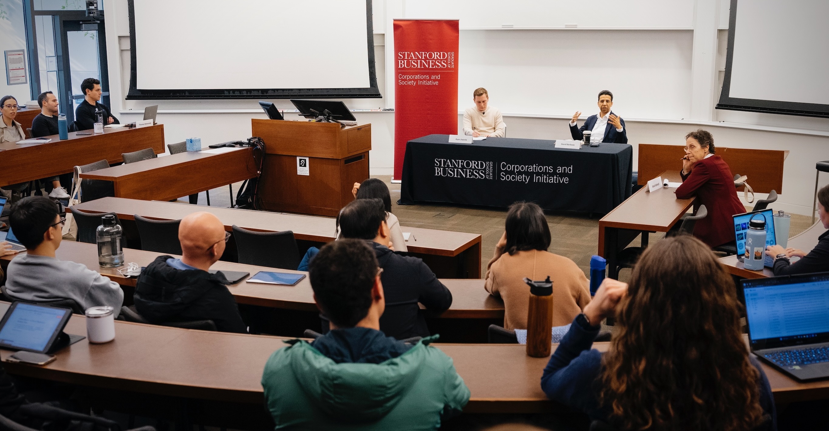 David Barboza speaking with Ryan Zepeda in a Stanford classroom, with students listening