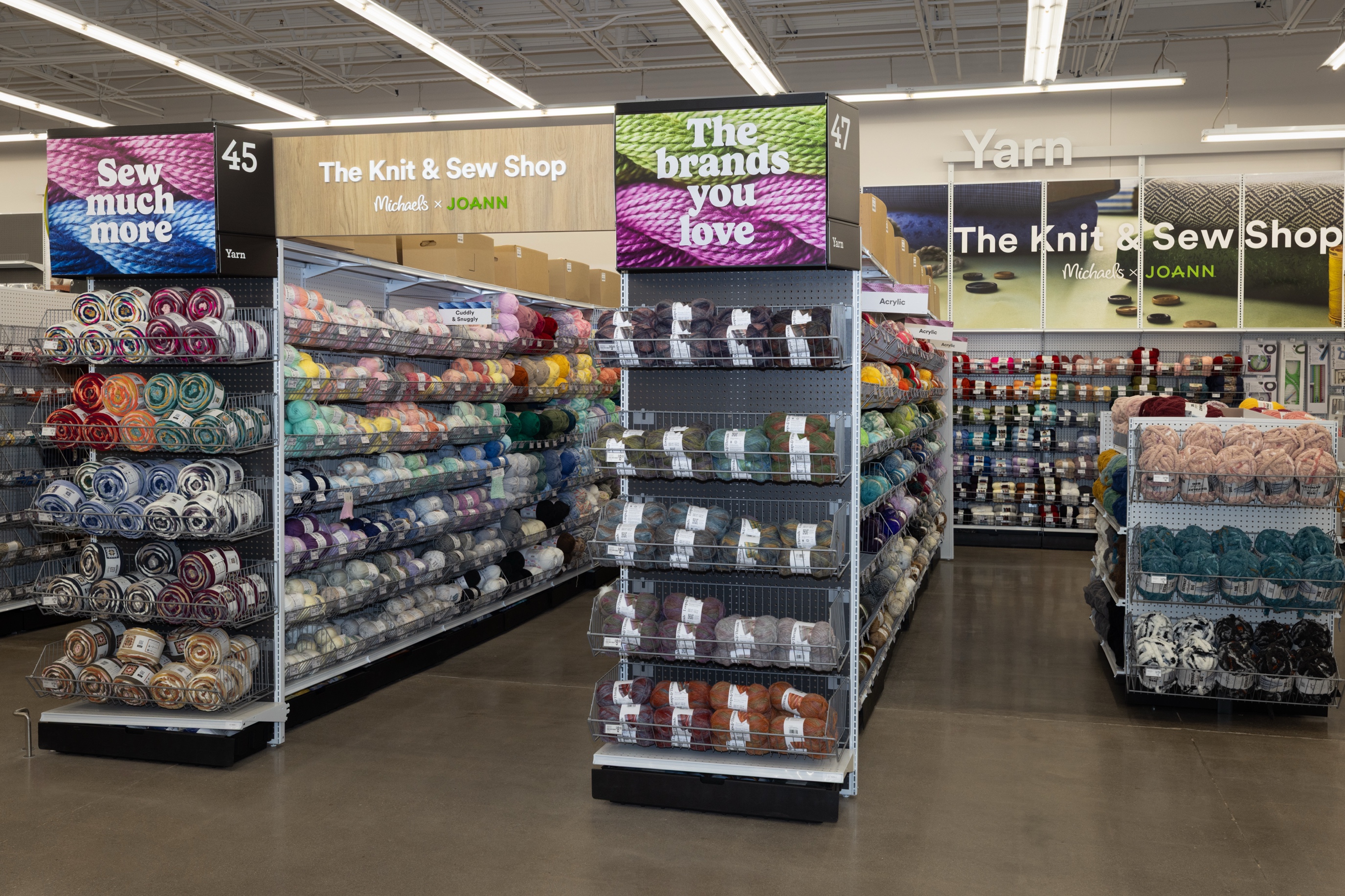 The Knit and Sew Shop at Michaels, with Michaels and Joann branding above shelves of yarn