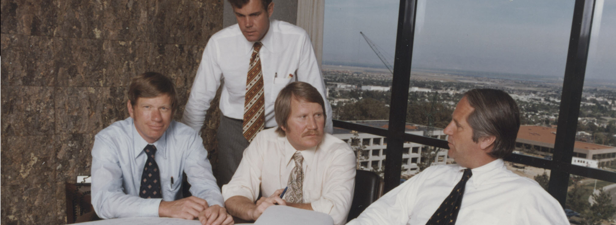 Archival photograph of Webcor’s four founders gathered around a table