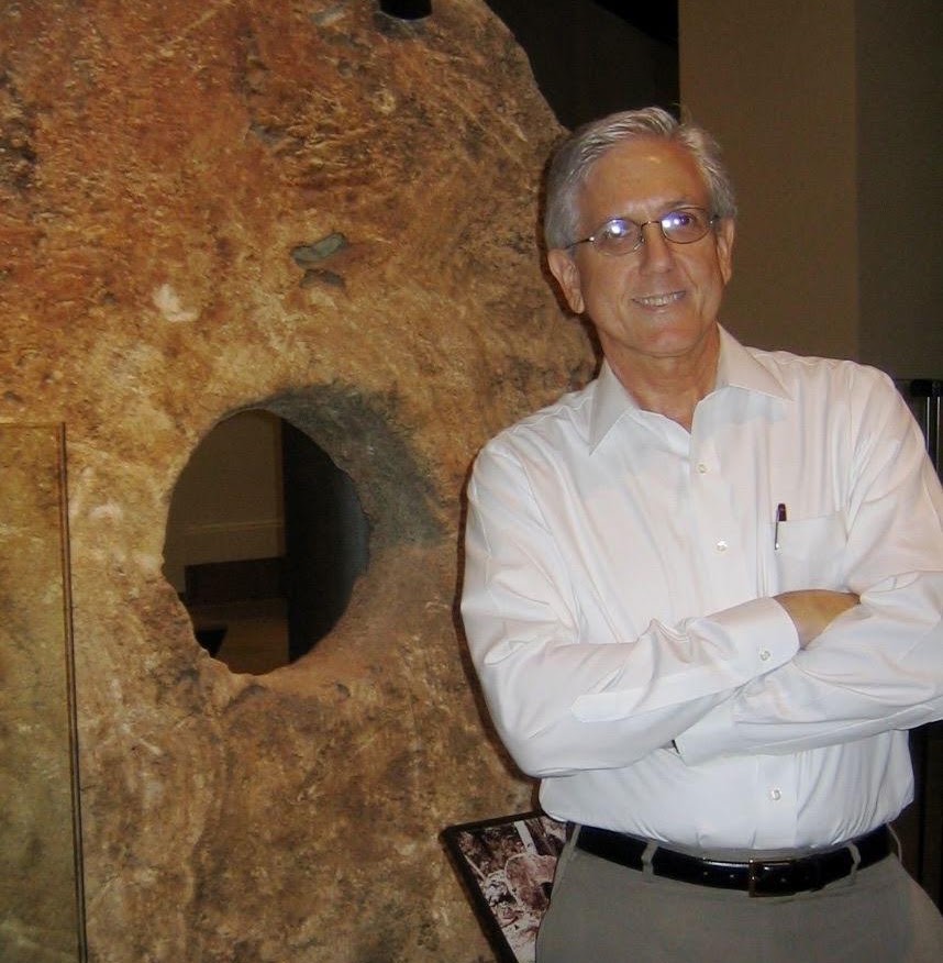 David Chandler Thomas standing beside a large Yap stone currency exhibit at the Smithsonian
