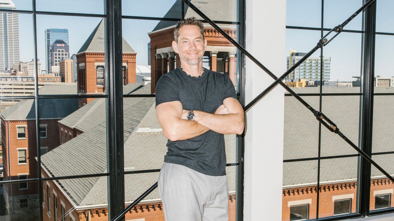 David DeRam standing in front of windows overlooking Indianapolis