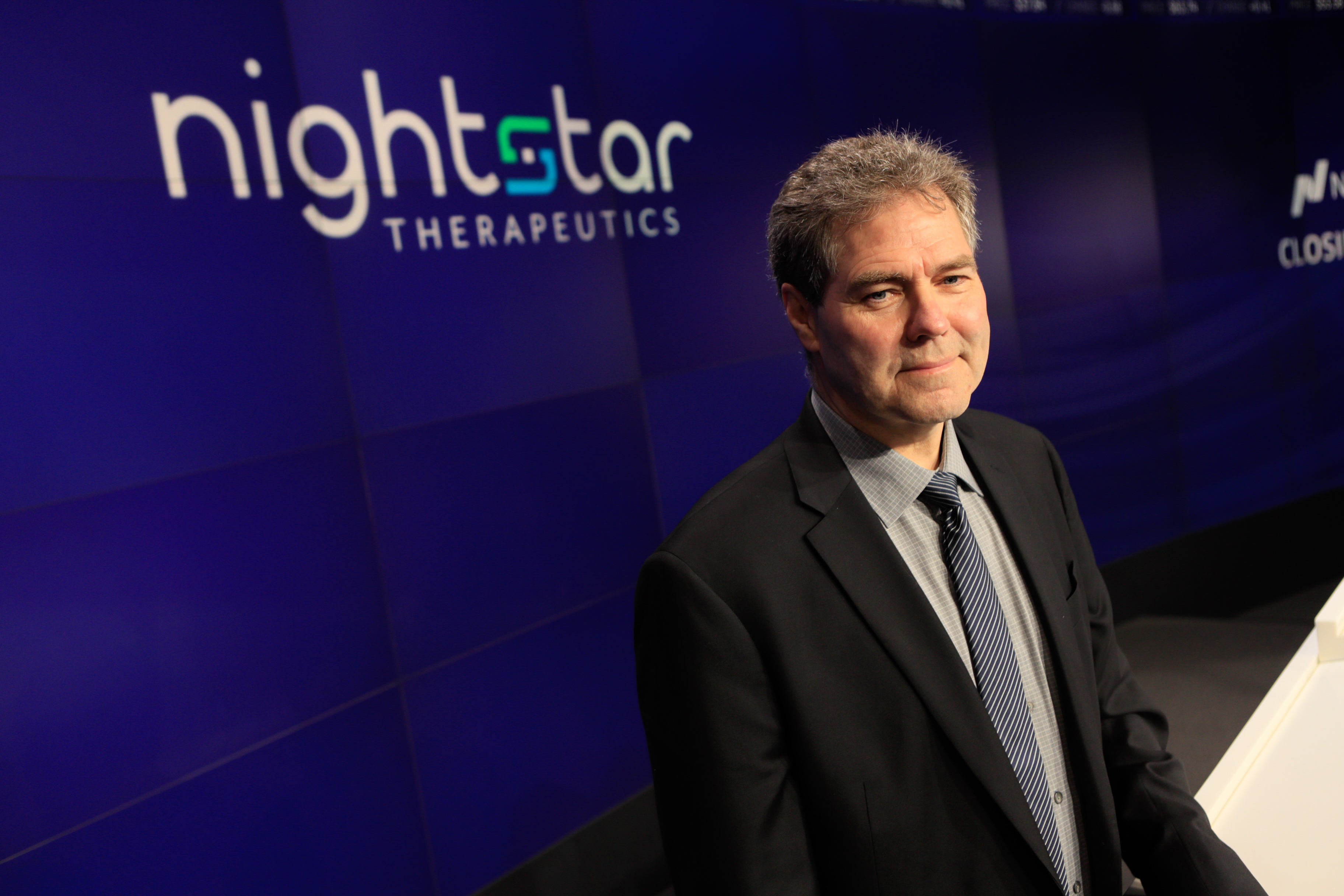 David Fellows at the Nasdaq MarketSite, beside Nightstar branding
