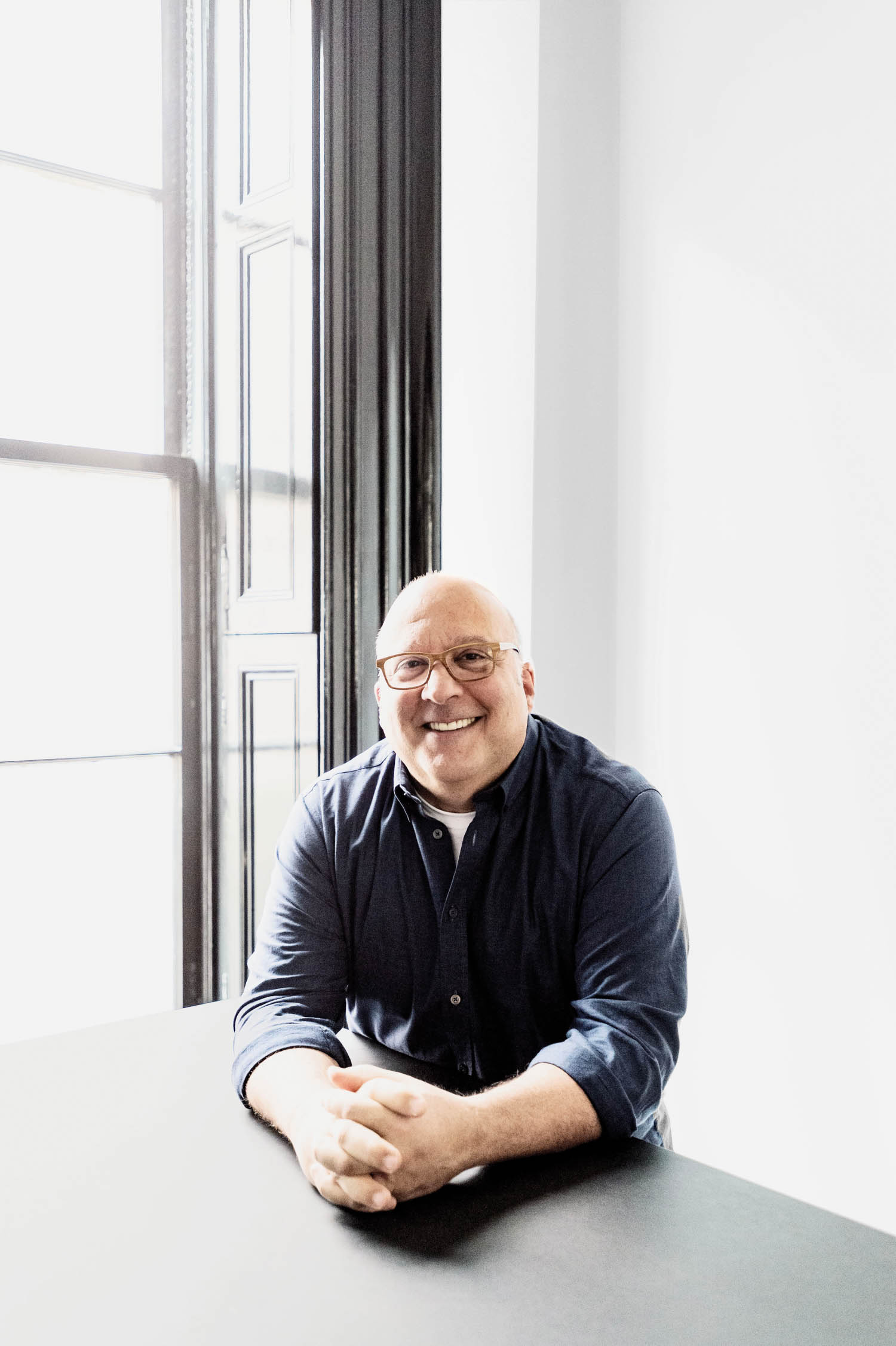 David Galullo seated beside tall windows at Rapt Studio’s former Manhattan office