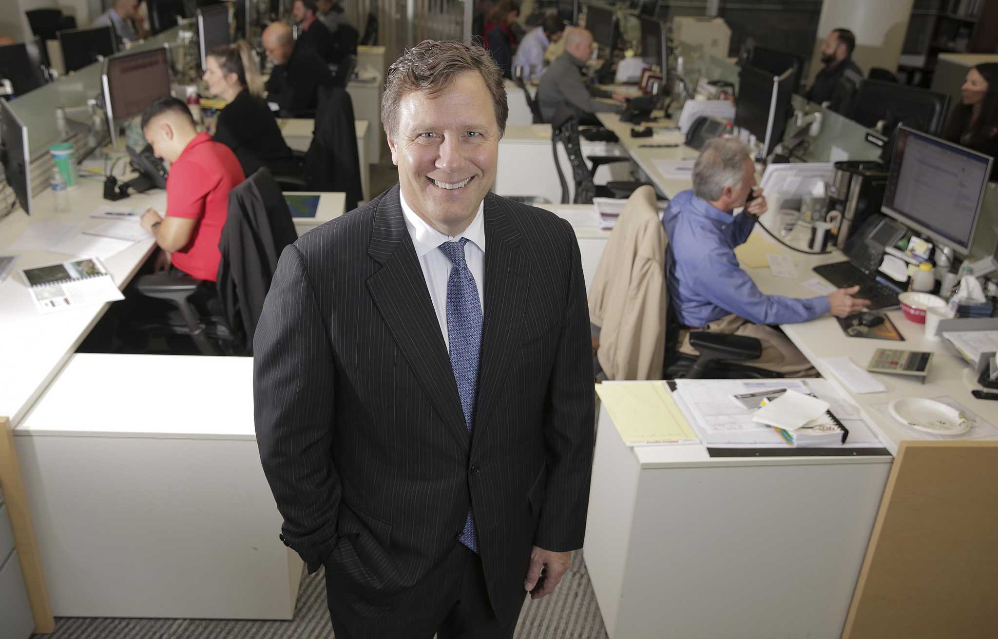 David Grzebinski standing among desks and colleagues in Kirby’s Houston office