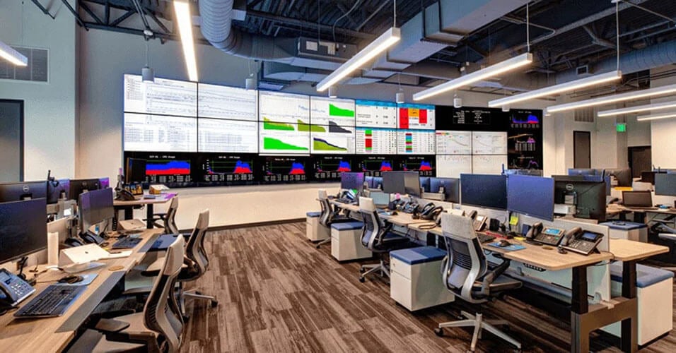 SpectrumVoIP network operations room with workstations facing a wall of operational dashboards