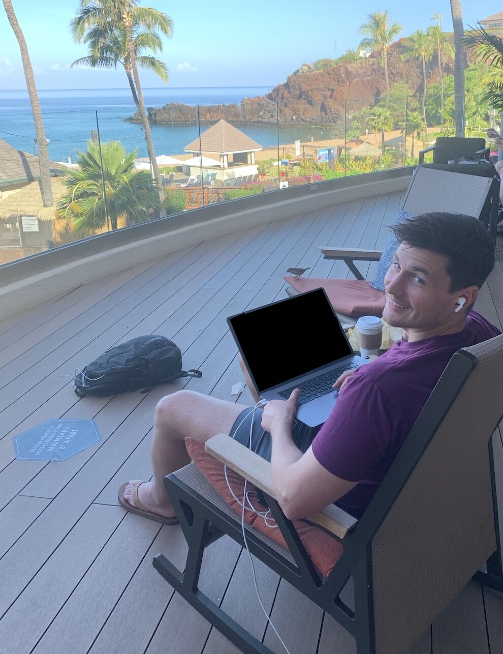 David Maulick working on a laptop in a chair overlooking the ocean