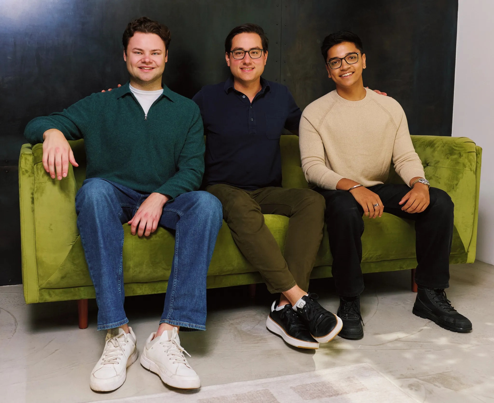David Paffenholz, David Cahn and Ishan Gupta seated together on a green sofa