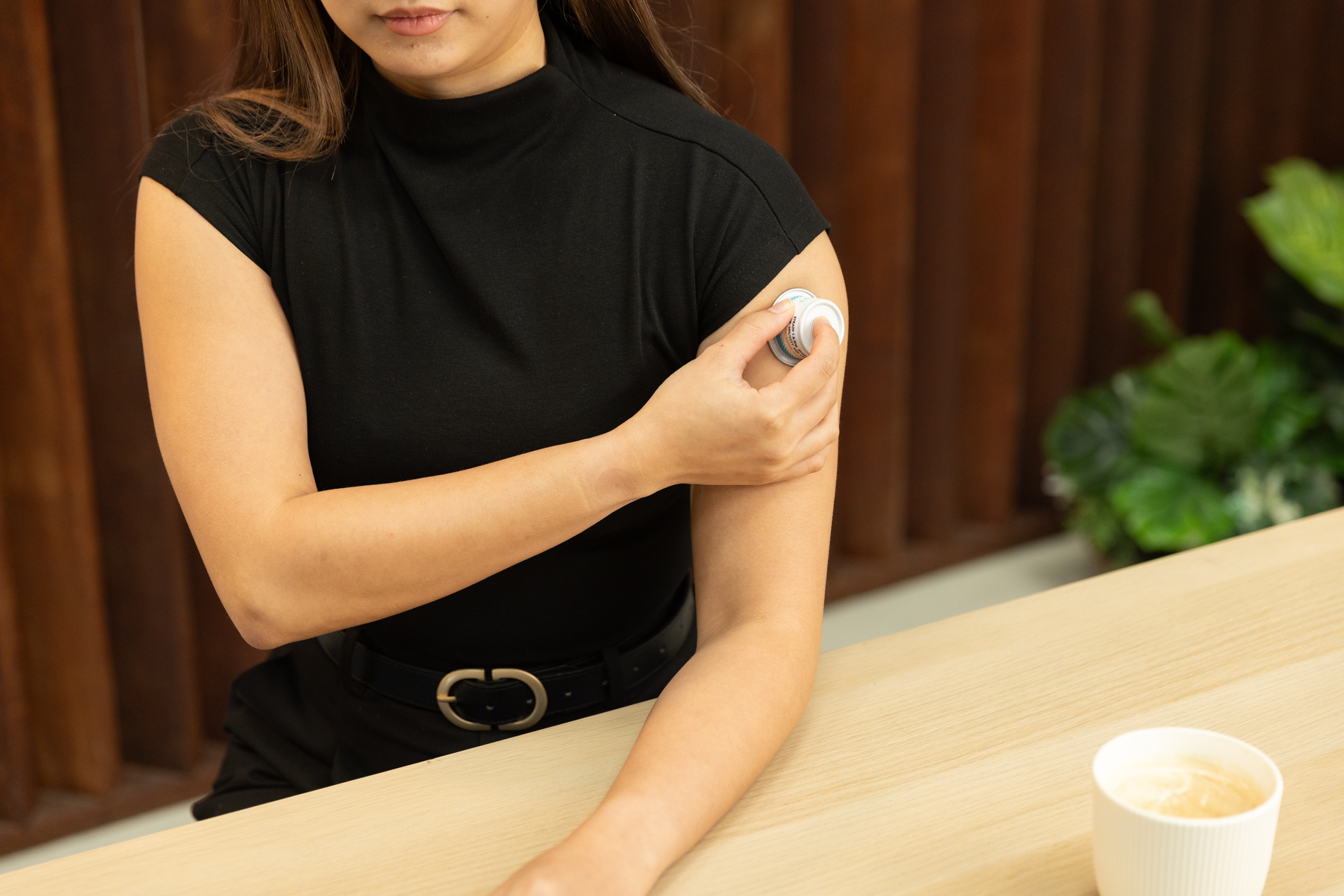 A person presses a Vaxxas HD-MAP applicator against an upper arm