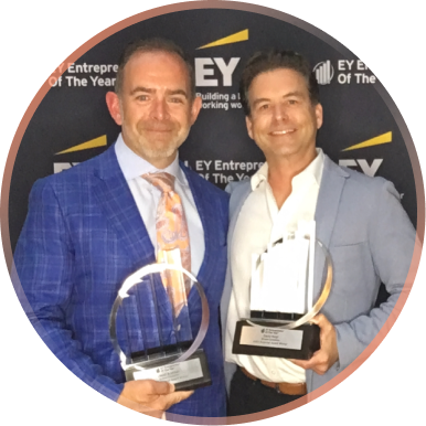 David Regn, at right, holding an award at an EY Entrepreneur Of The Year event