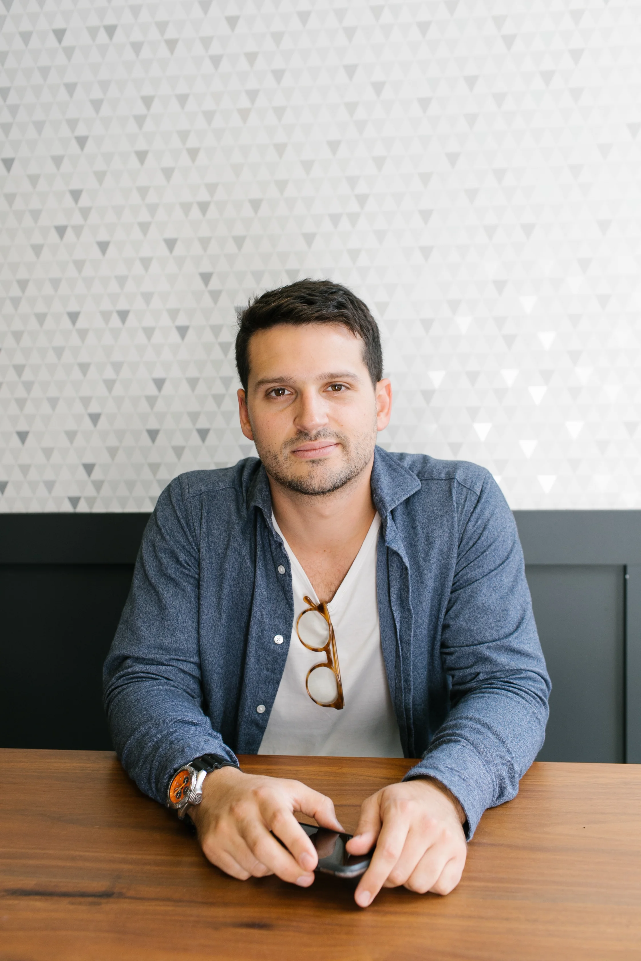 Portrait of David Roger seated at a wooden table