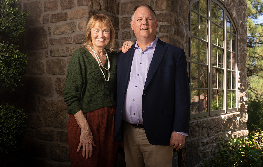 Ruth and David Singelyn standing together beside a stone building