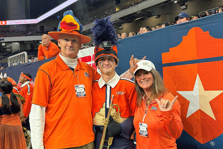 David and Jennifer Spencer with their son Sam in his UTSA marching-band uniform at a football game
