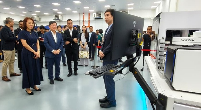 David Tian, behind Chow Kon Yeow and Loo Lee Lian, watches a demonstration at Galatek’s Penang facility.