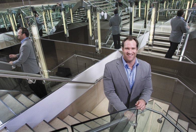 David Viger standing on a staircase surrounded by mirrors in a 2011 workplace portrait