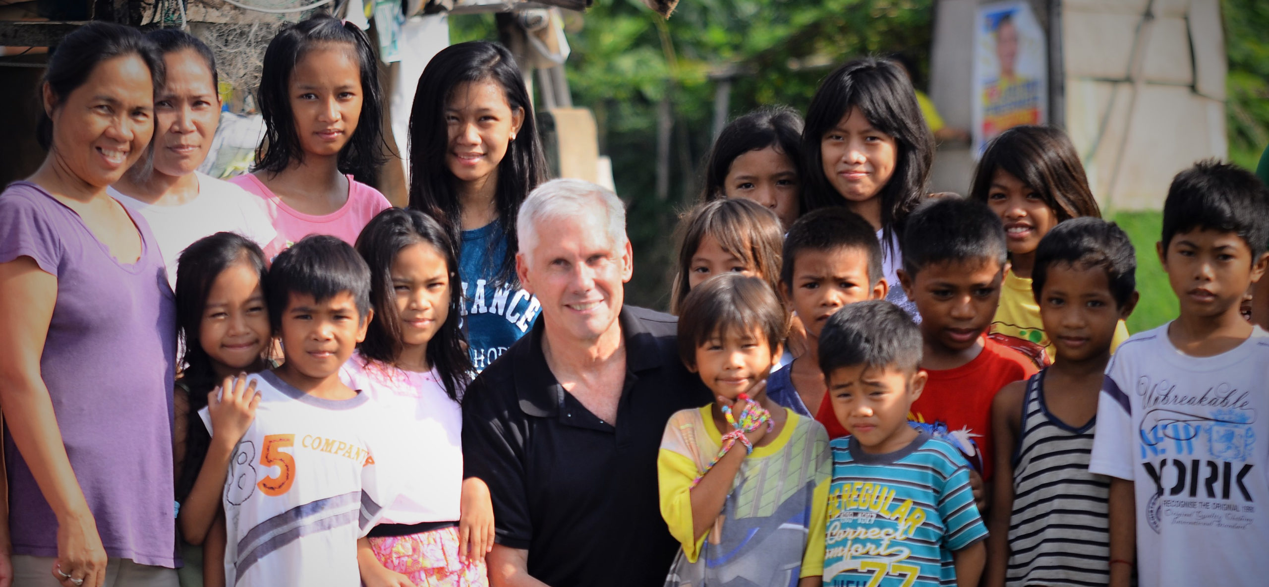 David West seated at the center of a group of adults and children in a photograph published by Civicom