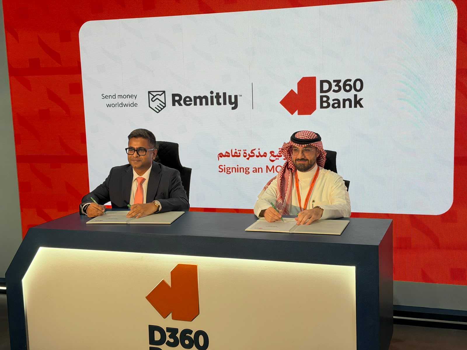 Davis Parakal, left, seated at a signing table for the Remitly and D360 Bank memorandum of understanding