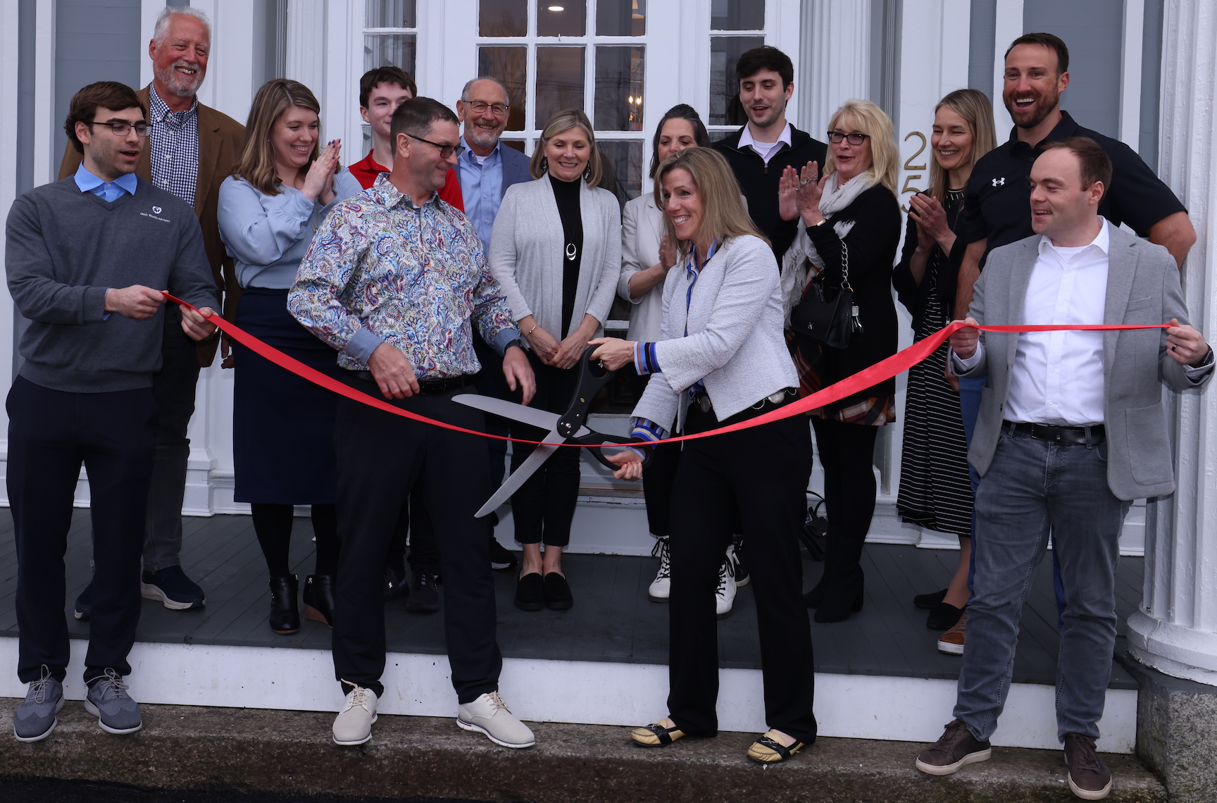 Dawn Smith and a group outside Oasis Wealth Advisors at the April 2024 office ribbon-cutting
