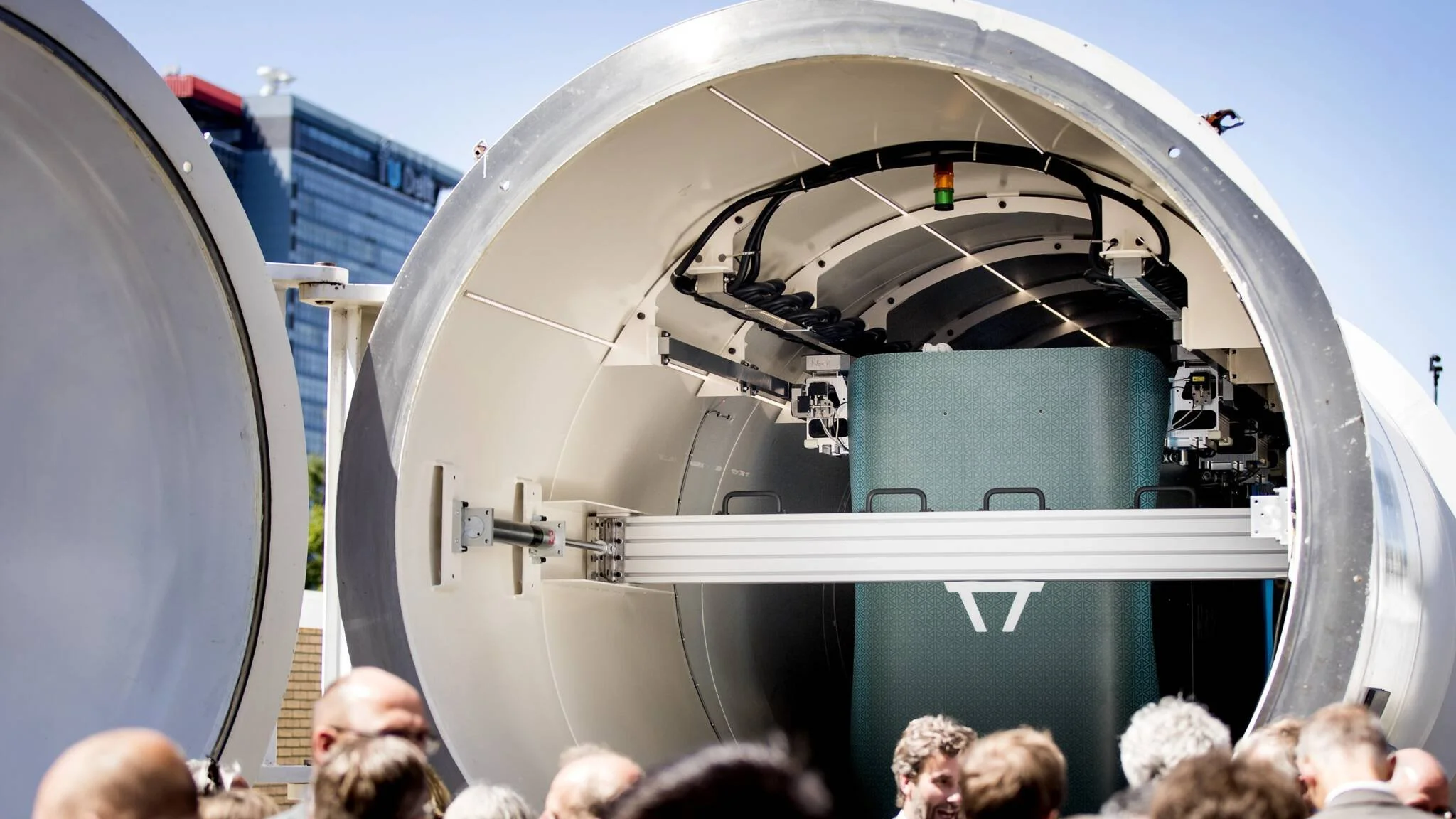 Visitors look into a large open hyperloop tube containing Hardt equipment.