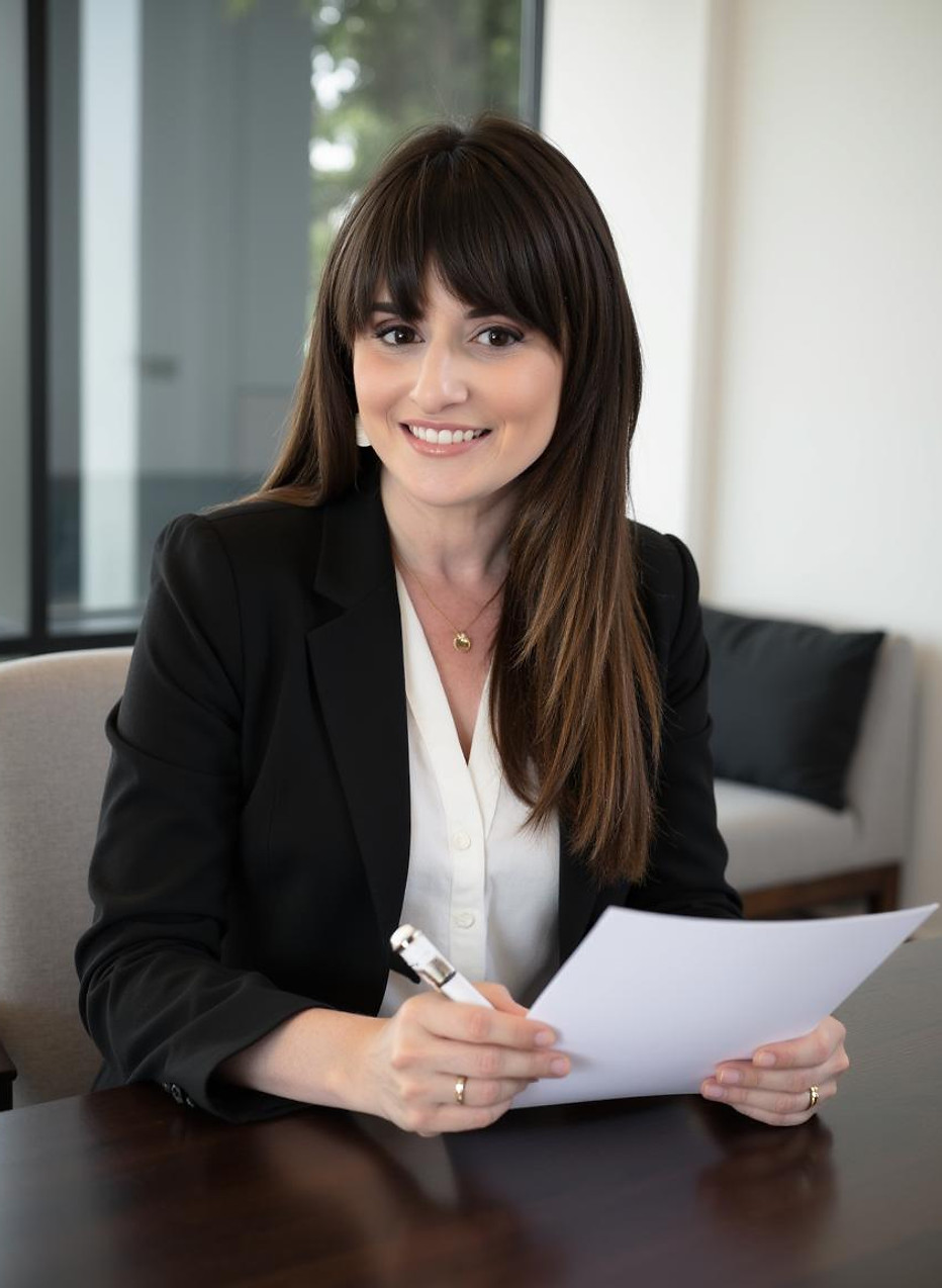 Dayna Rothman seated at a table with papers and a pen