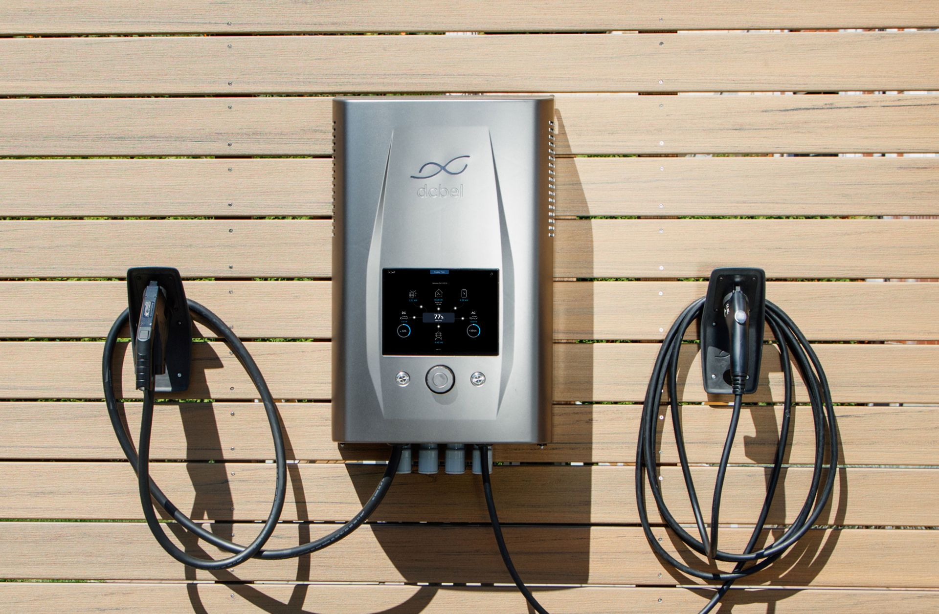 The silver dcbel Ara home energy station mounted on a dark exterior wall