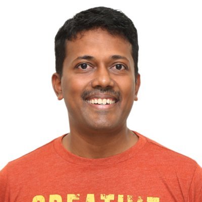 DCKAP founder and CEO Karthik Chidambaram smiling in a red shirt