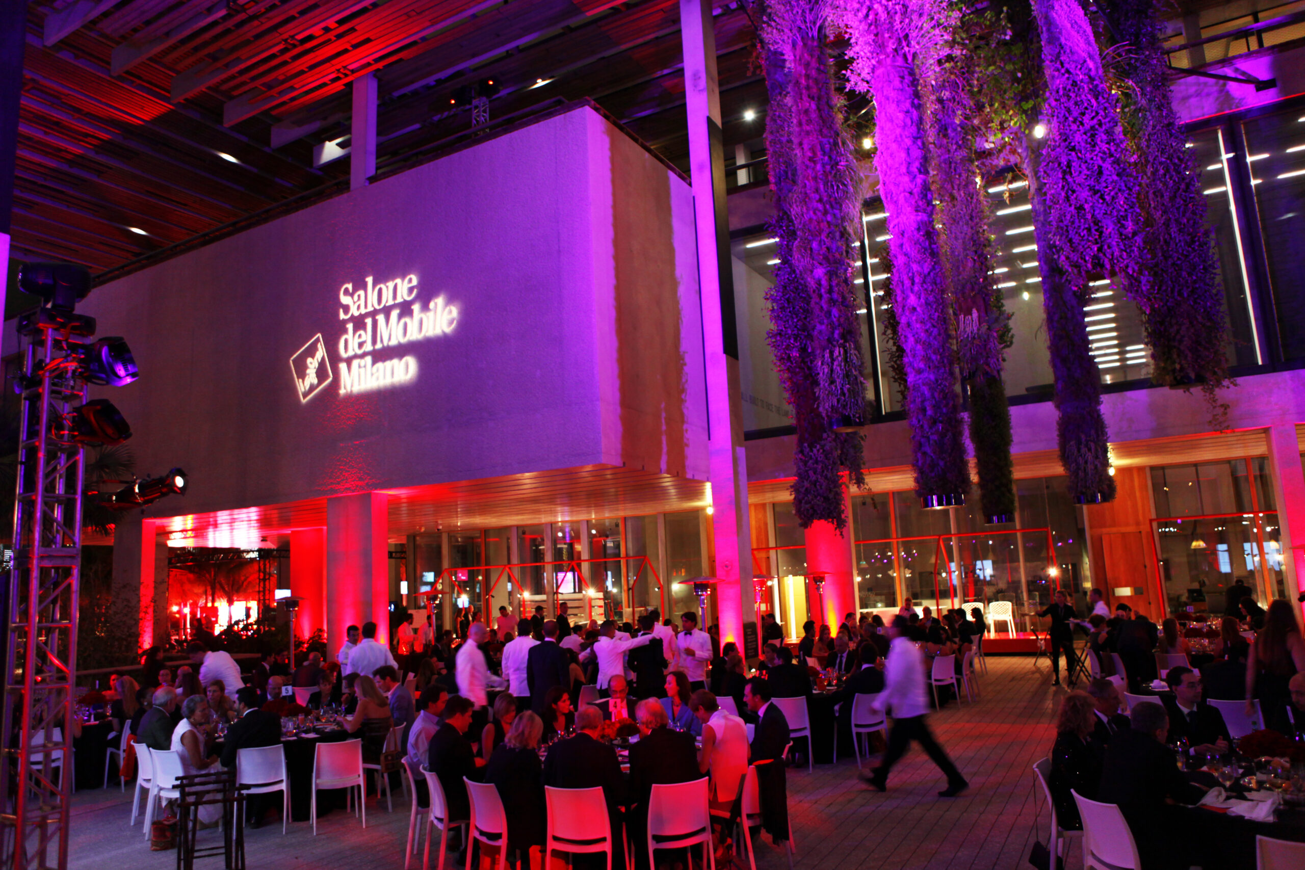 Guests seated at Salone del Mobile Meets Miami, with the event identity projected on the museum wall
