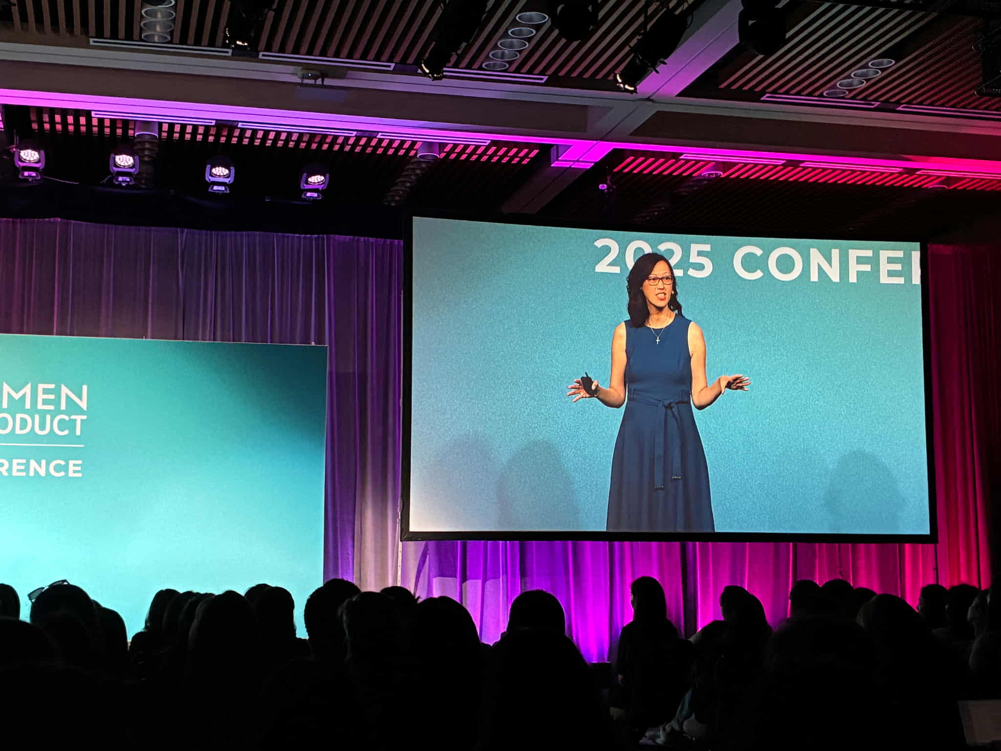 Deb Liu speaking on stage at the 2025 Women In Product conference
