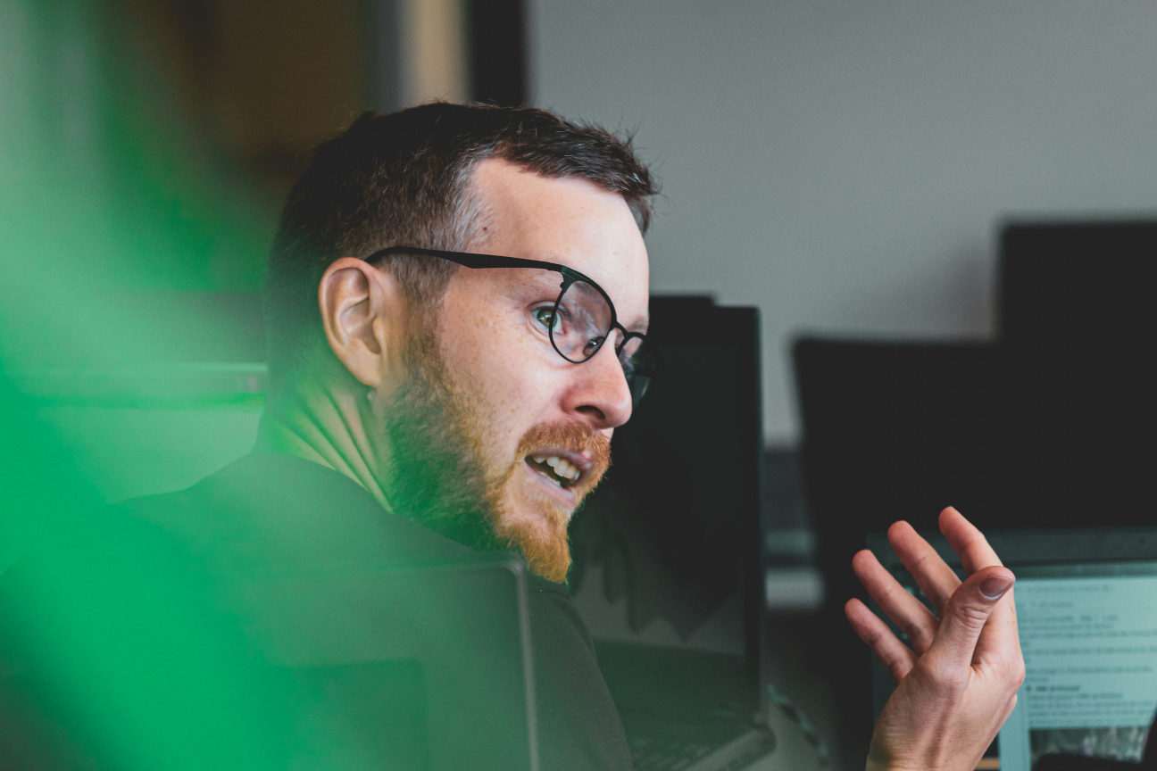 A Deep Genomics team member talking beside computer monitors