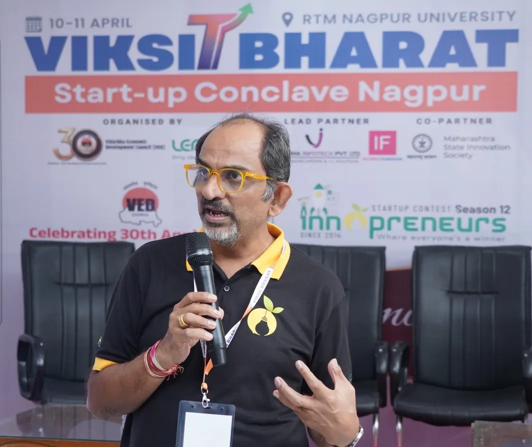 Deepak Menaria speaking into a microphone at the Viksit Bharat Start-up Conclave in Nagpur
