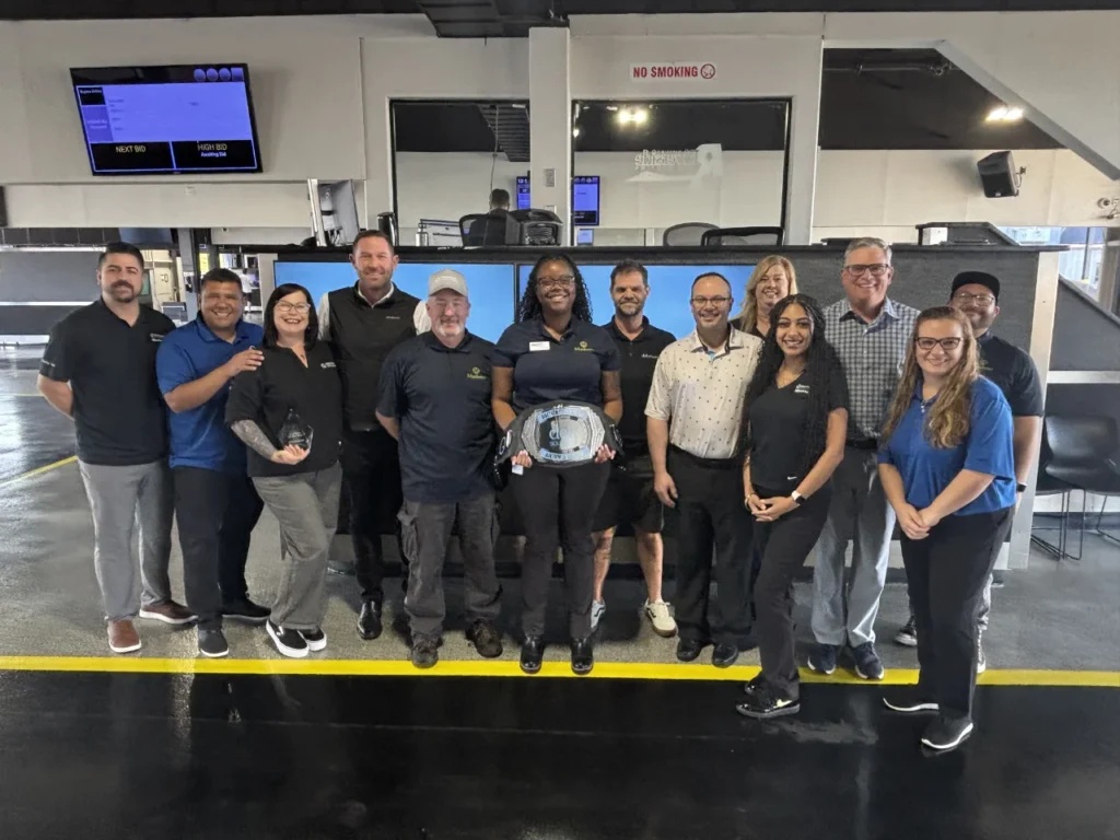 A group poses with an award at the Manheim Riverside auction facility