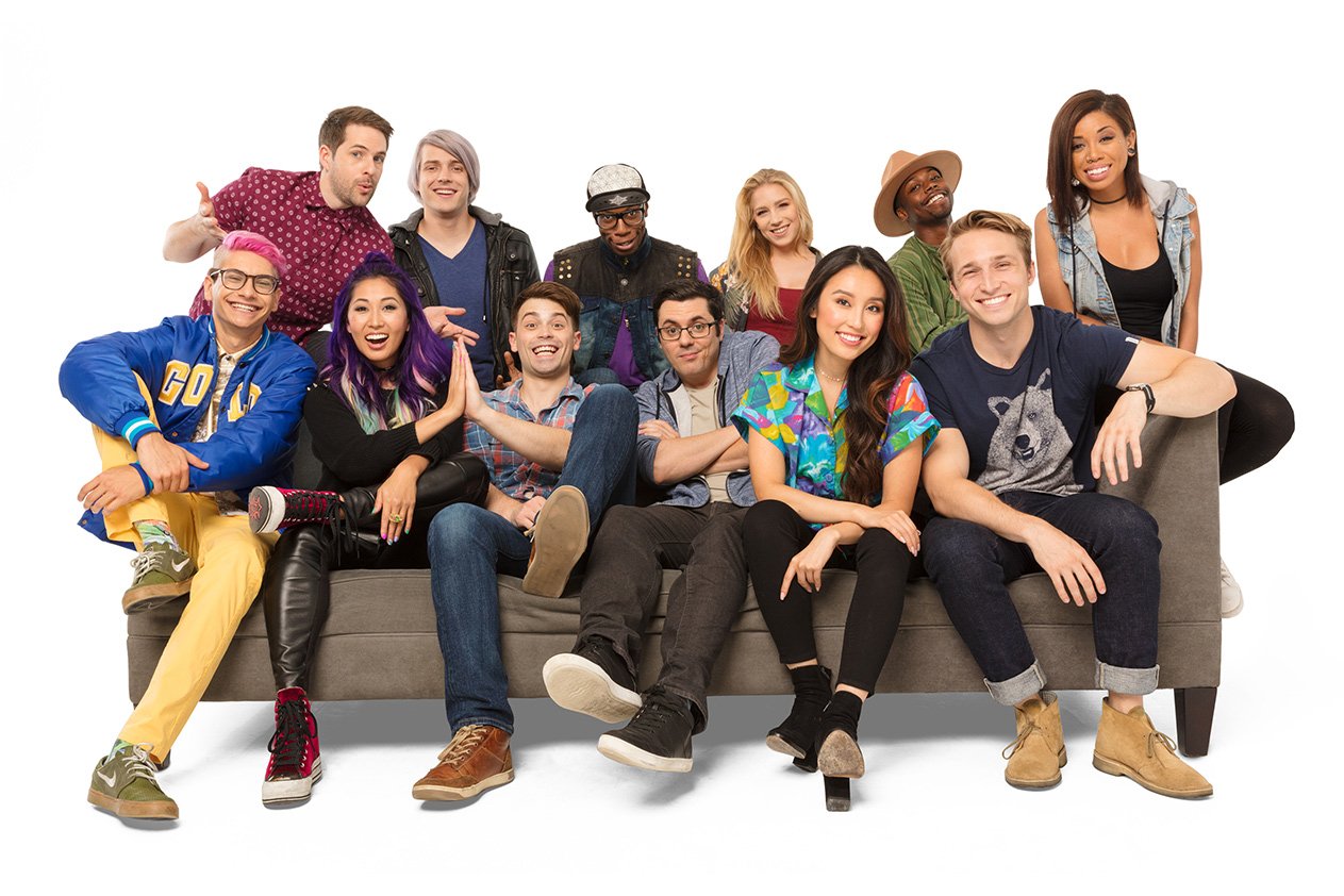 Smosh cast members gathered on and around a sofa in a studio press portrait
