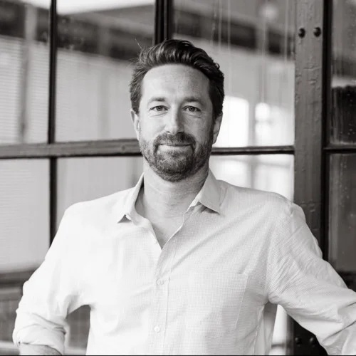 Deke George standing beside an industrial-style window