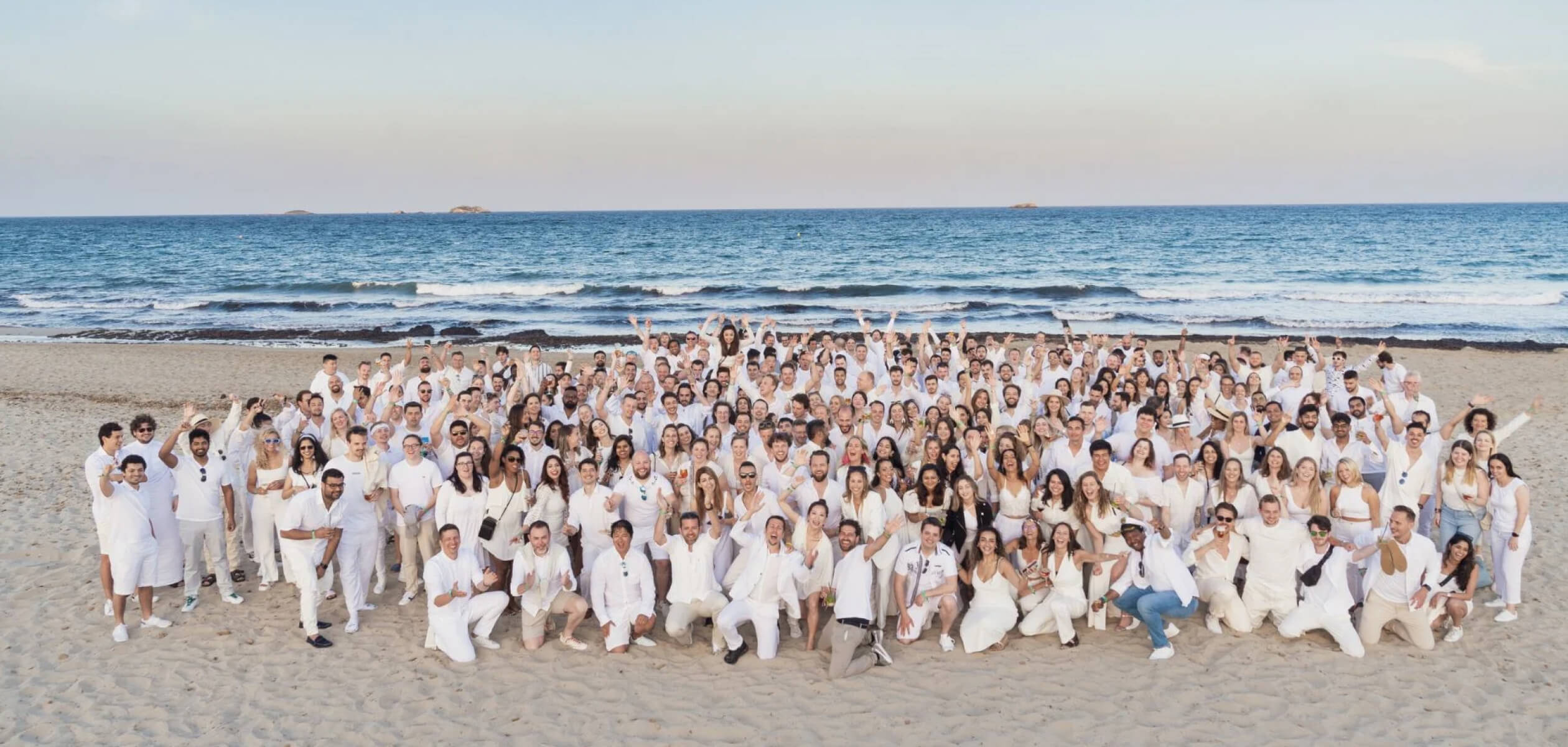 Deliverect team gathered on a beach during its 2022 Ibiza company trip