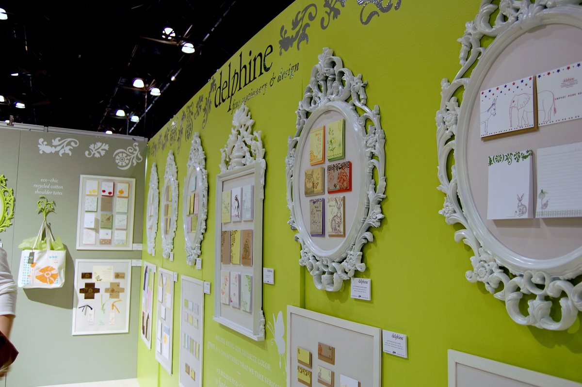 Delphine’s 2008 stationery show booth, with white decorative frames on a yellow-green wall