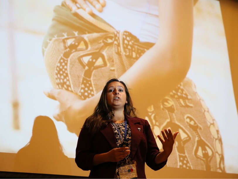 Denali Dahl speaking onstage during a presentation
