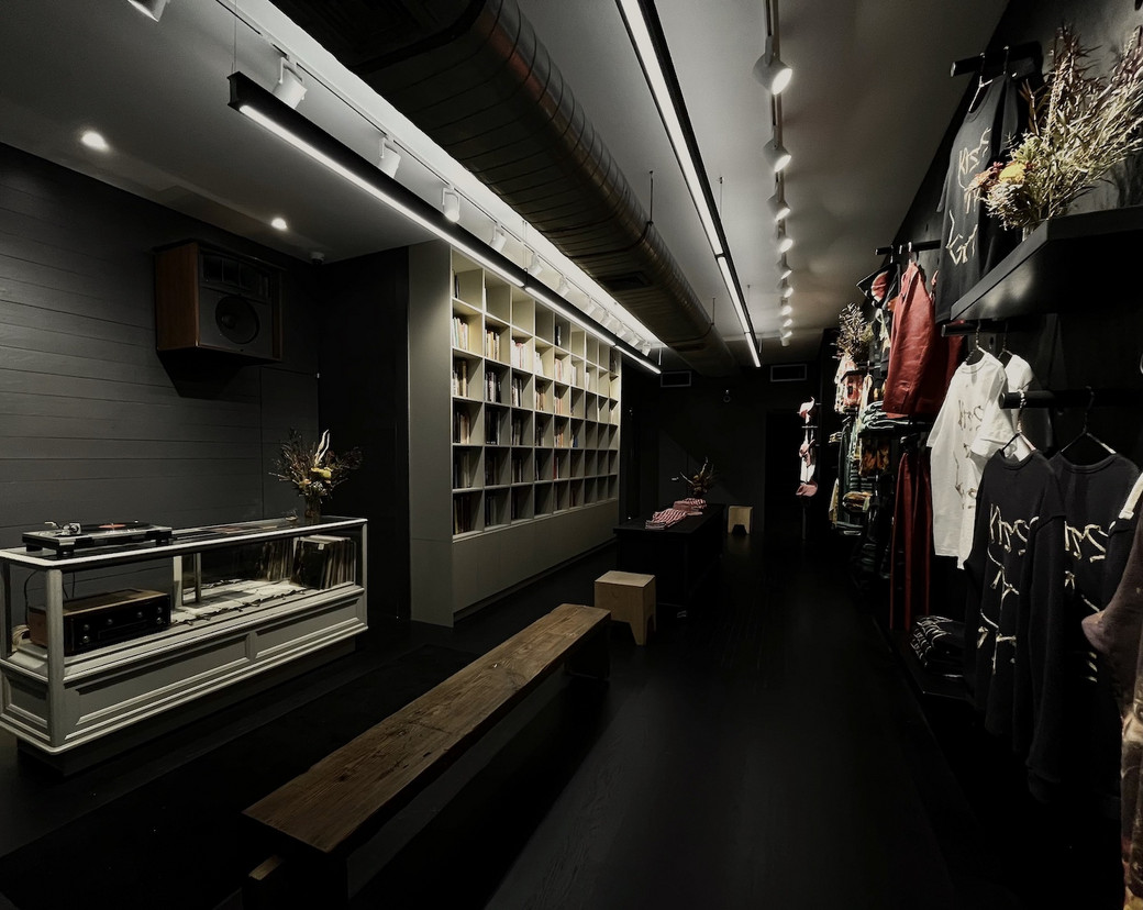 Inside African Diaspora Goods, with bookshelves, a long bench and clothing displays