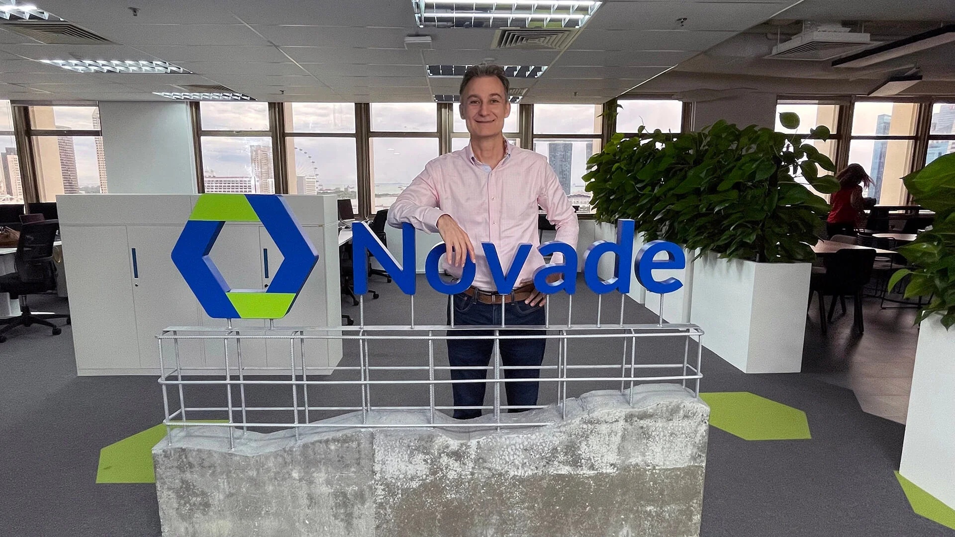 Denis Branthonne standing behind a Novade sign in the company office