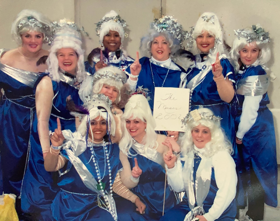 Founding members of the Krewe of Muses in blue and silver costumes, with Denise Estopinal at far right