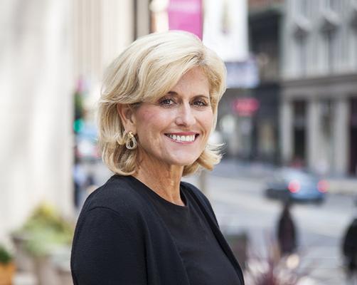 Denise Thomas smiling outdoors on a city street