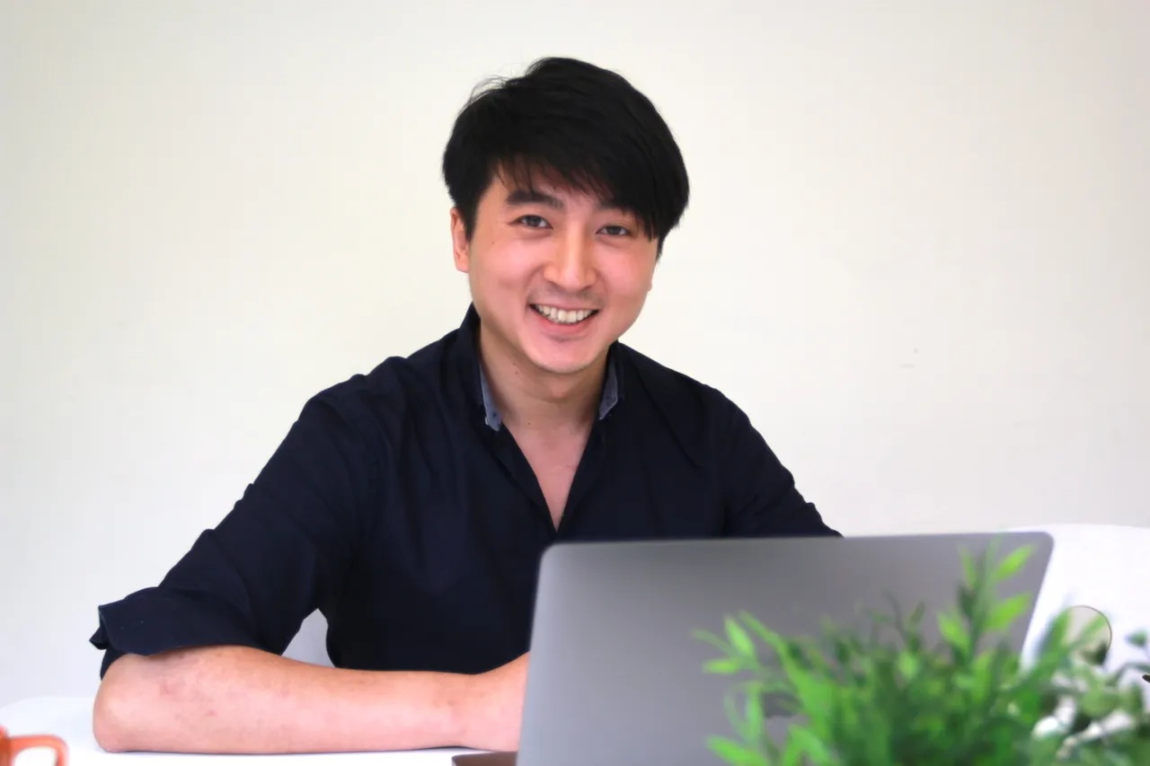 Dennis Lin seated behind a laptop during an early PressPlay interview