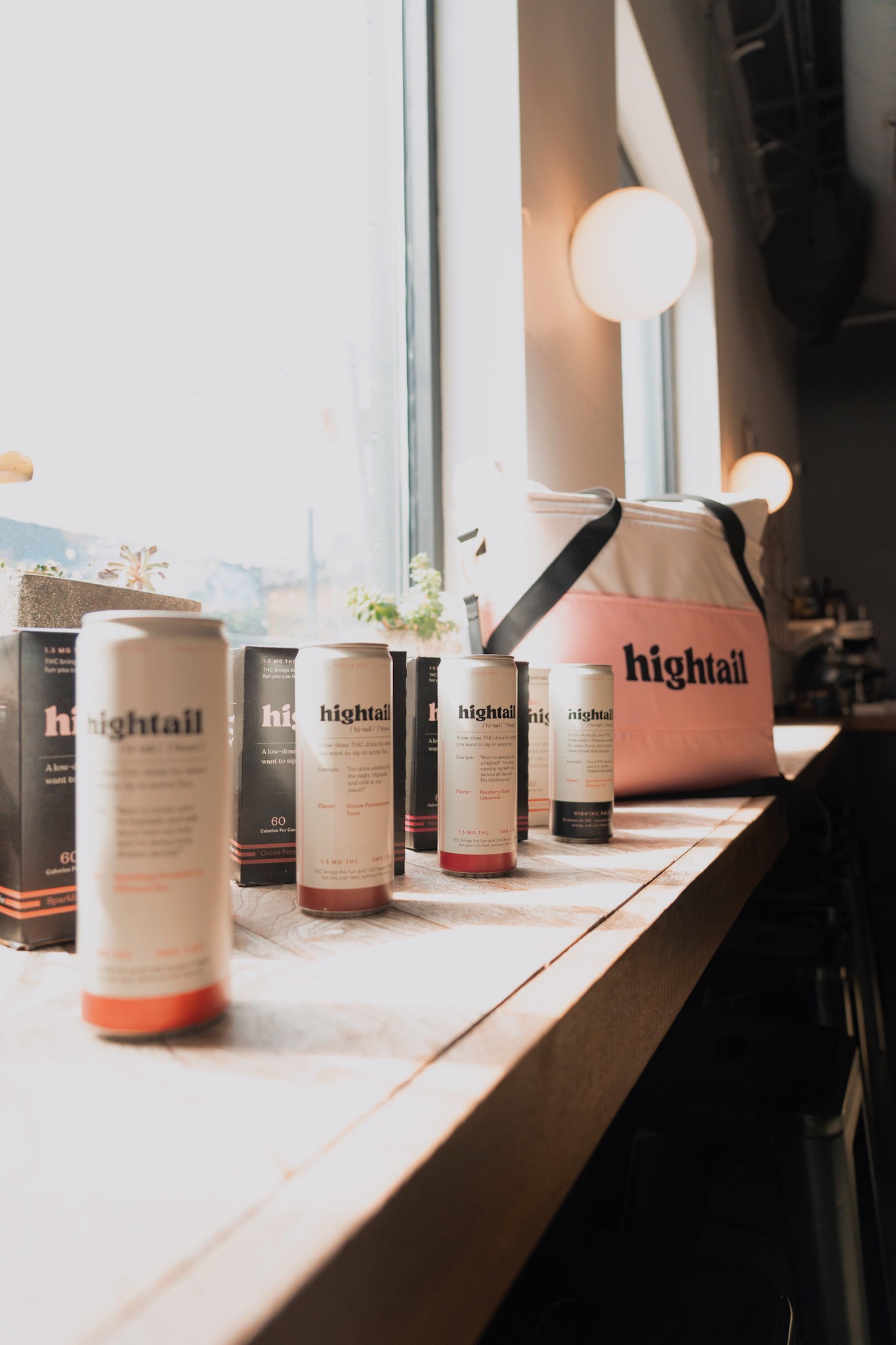 Cans of hightail drinks arranged on a sunlit Chicago bar