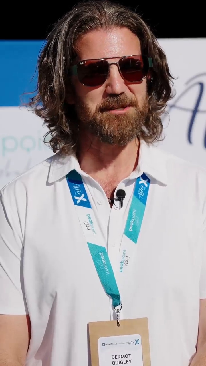 Dermot Quigley wearing sunglasses and an AfterX event lanyard during his Travelgate interview
