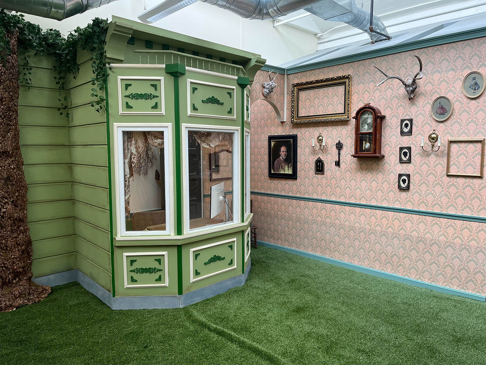 A theatrical green booth and framed decorations inside Descript’s office