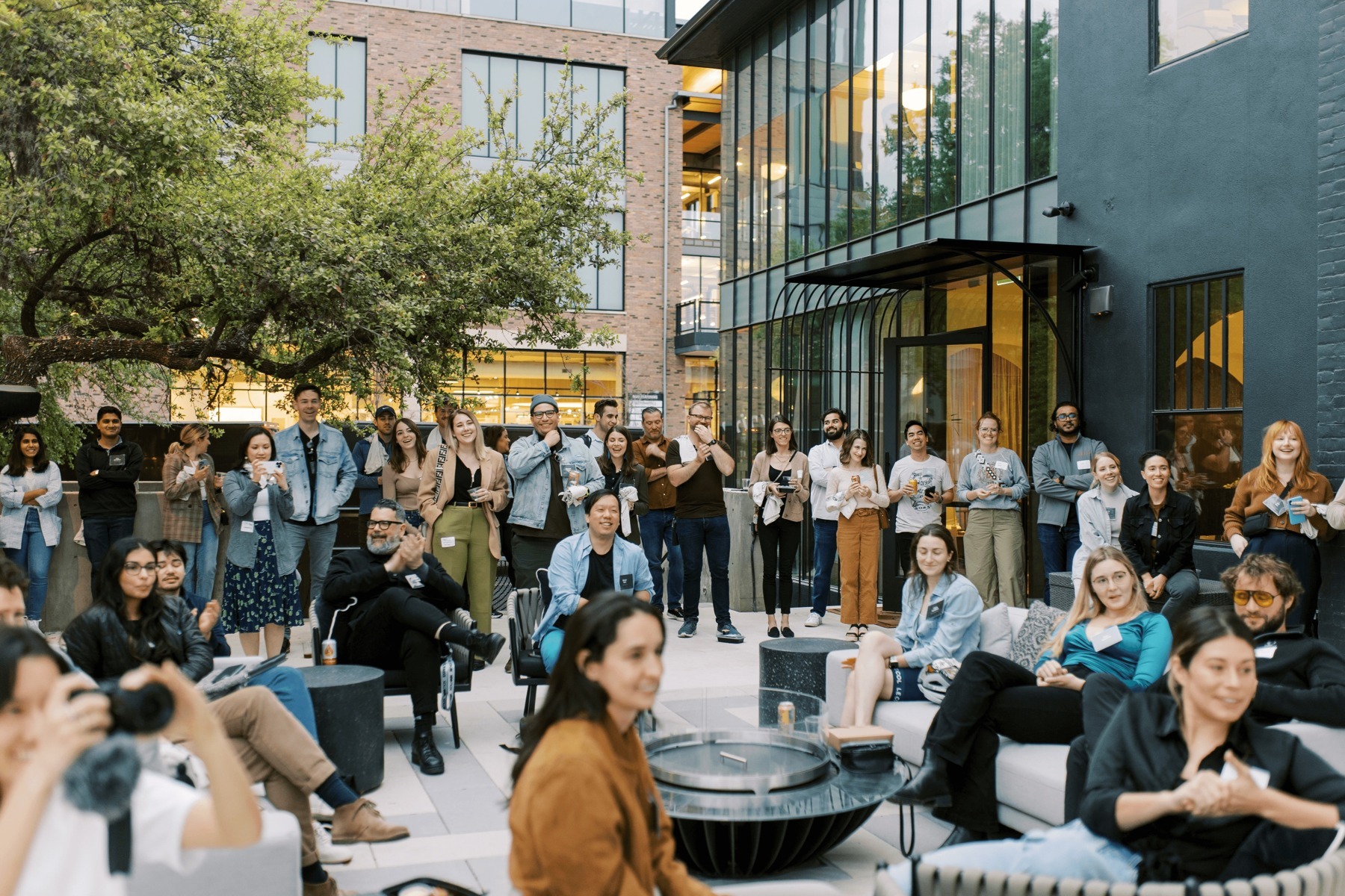 People gathered in an outdoor courtyard at a Designer Fund community event