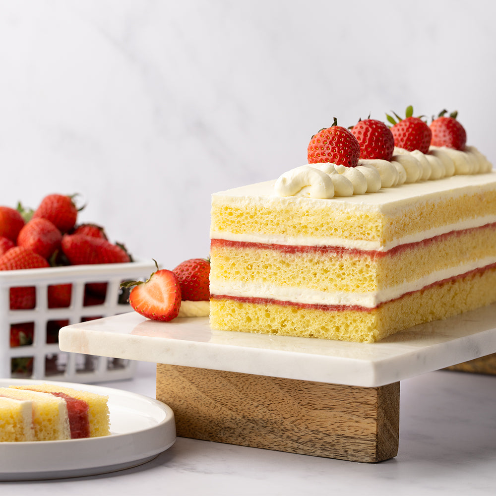 A finished strawberry multi-layer cake with fresh berries